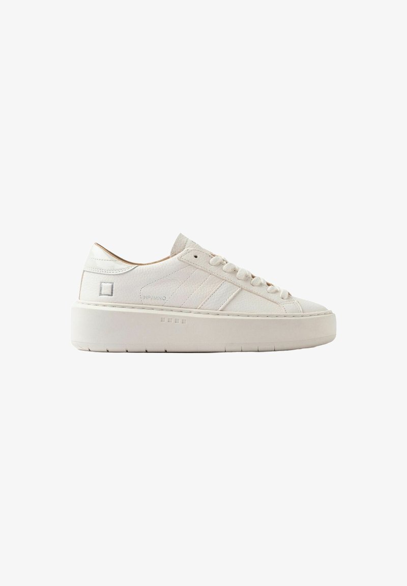 Hvide lave lædersneakers med tyk sål, sidesyninger og snørebåndslukning på en ensfarvet hvid baggrund.