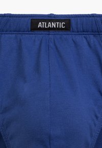 Niebieska bawełniana bielizna z czarną metką z napisem "ATLANTIC". Materiał jest gładki z lekkim stretch'em, zaprojektowany z myślą o komforcie.