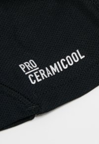 Zwart sportstof met "PRO CERAMICOOL" in vetgedrukte witte letters, met een gestructureerd oppervlak en naadloze randen.
