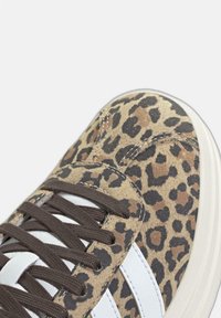Sneakers med leopardmönster med en mjuk, mockaliknande ovandel i brunt, accentuerad med vita läderremsor och bruna sn ören. Rundad tådesign.