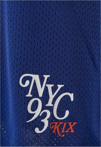 Blå mesh-stoff med små perforeringer, har hvit tekst "NYC 93" og "K1X" i oransje. Enkelt design med sporty estetikk.