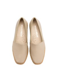 Beżowe skórzane buty wsuwane z zaokrąglonym noskiem, elastycznymi bokami oraz plecioną, jutową podeszwą. Widoczne otwory wentylacyjne na wkładce.