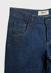 Donkerblauwe denim jeans met een klassieke vijf-pocket ontwerpen, zichtbare stiksel details en een knoopsluiting. Etiket toont maat 38.