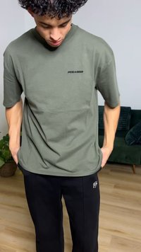 Olive green short-sleeve t-shirt with a round neckline and "PEGADOR" logo in black. Paired with black pants featuring a small logo.
