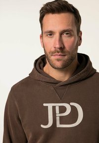 Felpa marrone con cappuccio caratterizzata da un grande logo bianco "JPD" sul davanti, con una texture morbida e design con cappuccio regolabile.