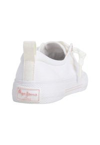 Sneaker bianco in tela con suola in gomma testurizzata, linguetta sul retro e accenti rosa discreti sul logo e sulle strisce laterali.