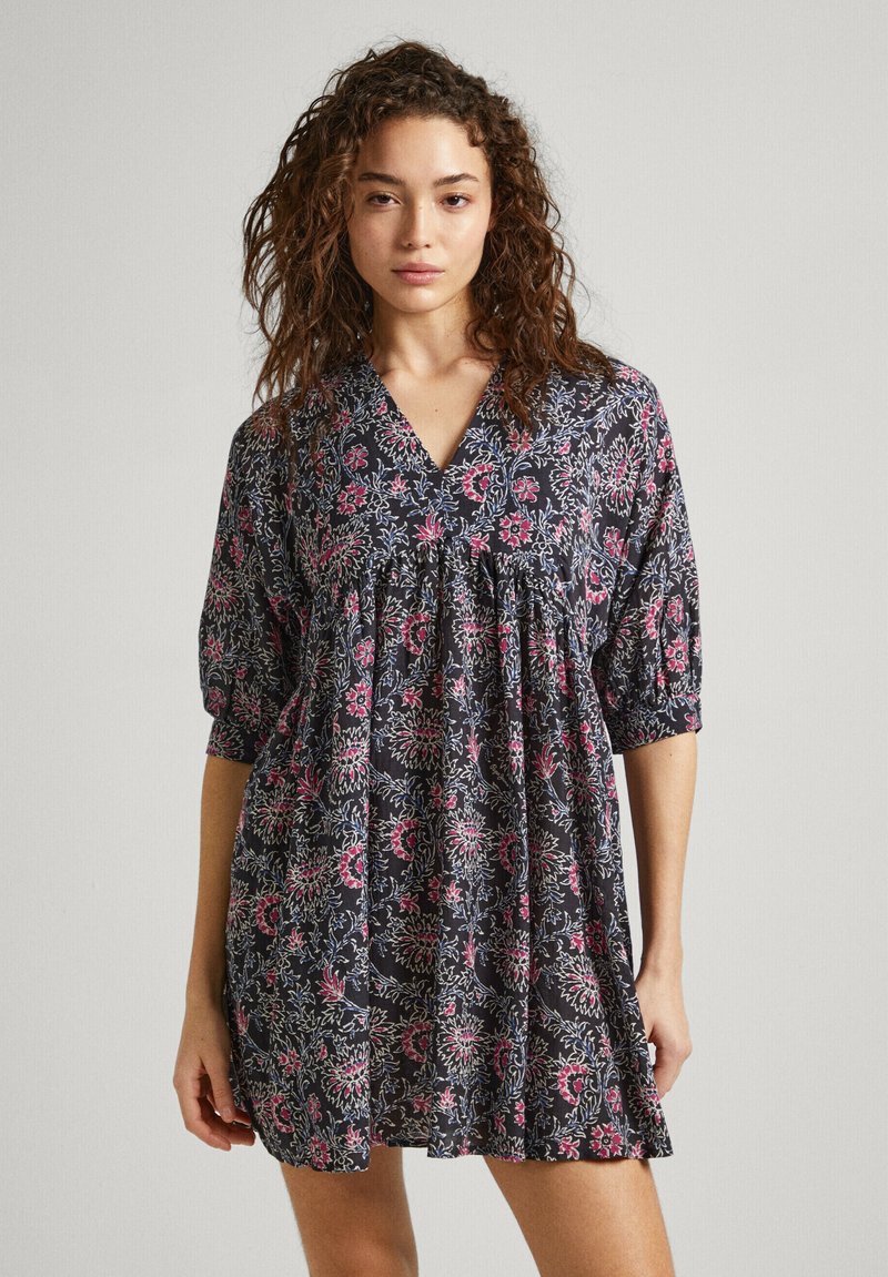 Abito stampato floreale con scollo a V, vestibilità comoda e maniche a metà. Sfondo scuro con motivi floreali rosa e bianchi. Tessuto leggero.