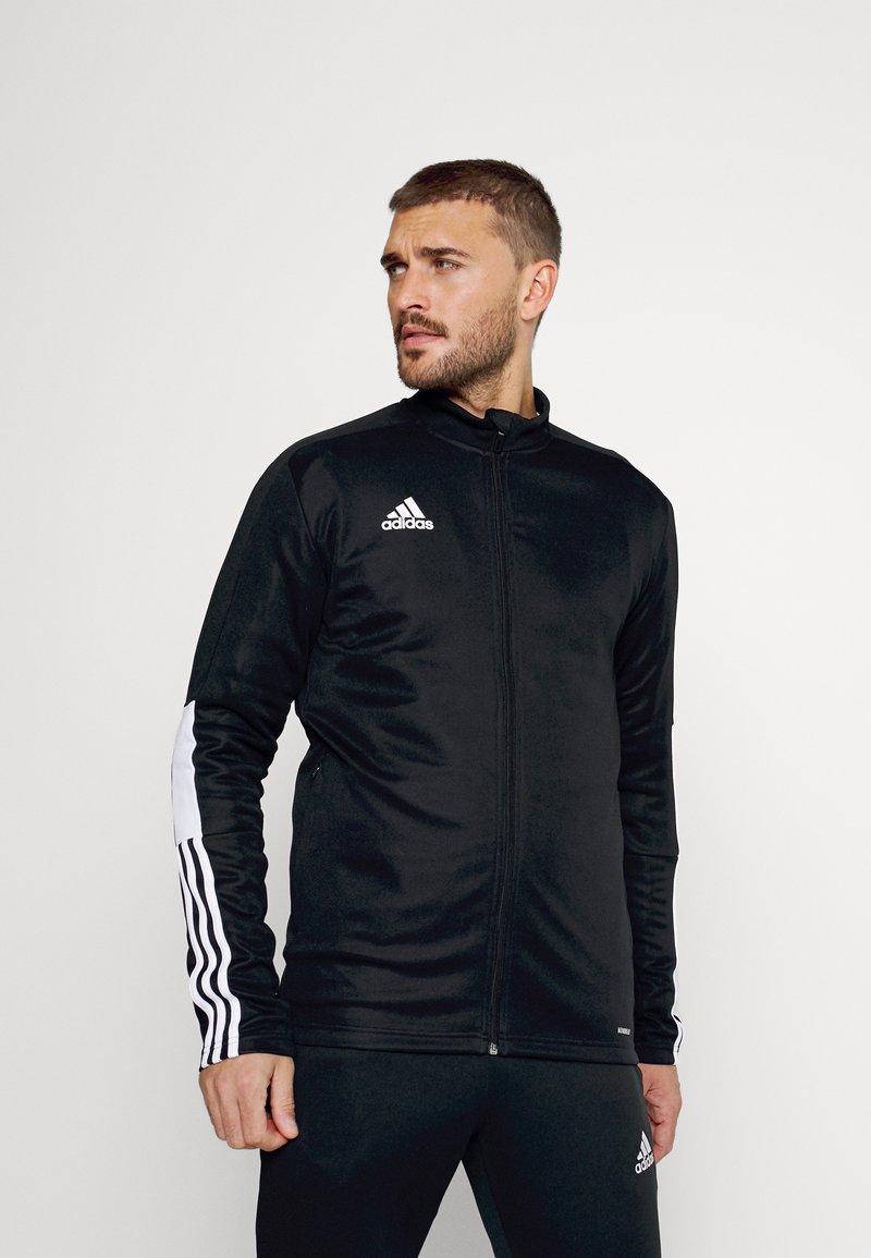 Zwarte sportieve zip-up jas met witte drie-strepen accenten op de mouwen en het Adidas-logo op de borst. Gemaakt van gladde, rekbare stof.