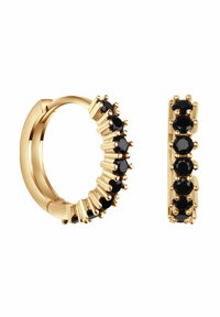 Złote kolczyki w kształcie kółek z czarnymi kamieniami osadzonymi w mocowaniu typu prong. Charakteryzują się gładkim wykończeniem i skomplikowanym zdobieniem wzdłuż krawędzi.