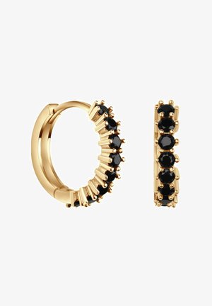 Złote kolczyki w kształcie kółek z czarnymi kamieniami osadzonymi w mocowaniu typu prong. Charakteryzują się gładkim wykończeniem i skomplikowanym zdobieniem wzdłuż krawędzi.