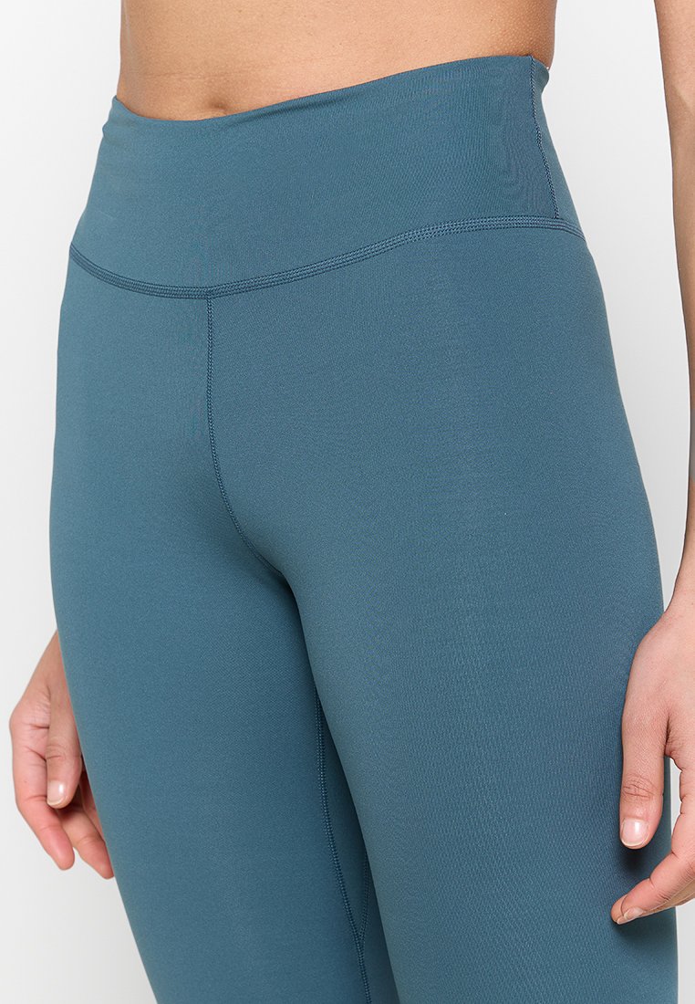 Leggings de talle alto en color teal, fabricados con un tejido elástico y suave; cuentan con costuras planas y un diseño ajustado para mayor comodidad y flexibilidad.