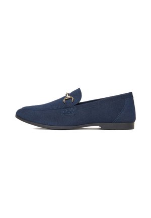 Marineblaue Wildleder-Loafer mit niedriger schwarzer Sohle und goldenem Metallriemen-Detail oben, Seitenansicht auf weißem Hintergrund.