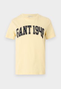 Sárga pamut póló, melyen sötétkék betűkkel "GANT 1949" felirat található a mellkason. Rövid ujjú, környakú kialakítás.