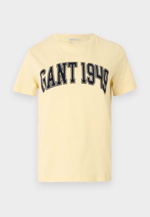 Geel katoenen T-shirt met daarop "GANT 1949" in donkerblauwe letters gedrukt over de borst. Korte mouwen en een ronde hals.