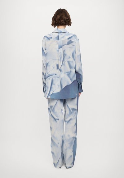 Light blue satin button-up shirt with a subtle abstract pattern, paired with matching wide-leg pants, both featuring a smooth texture.
