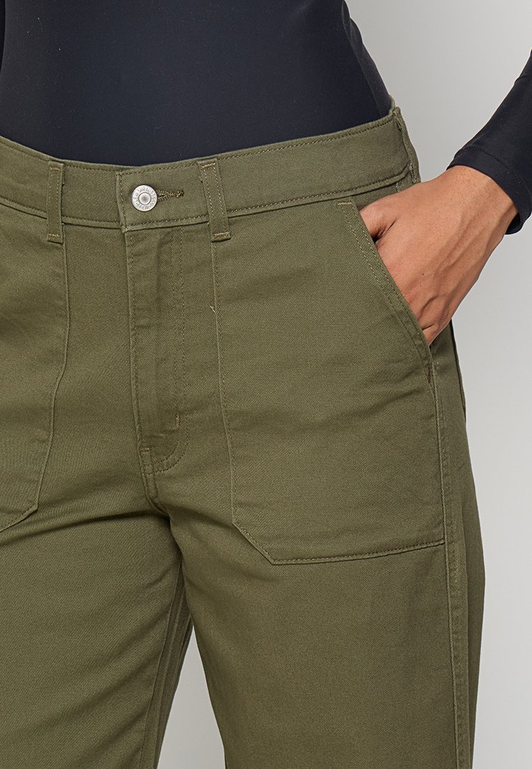 Pantalons en coton vert olive avec une coupe droite, présentant des poches avant, une fermeture par bouton supérieur et des détails de couture visibles.