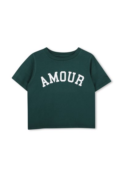 Σκούρο πράσινο cropped t-shirt με κοντά μανίκια και λευκά κεφαλαία γράμματα που σχηματίζουν την επιγραφή "AMOUR" σε τόξο στο στήθος.