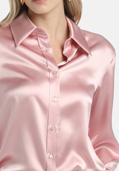 Helle rosa Satinbluse mit Knopfverschluss vorne, großem Kragen und glatter Textur. Verfügt über perlartige Knöpfe und eine lockere Passform.