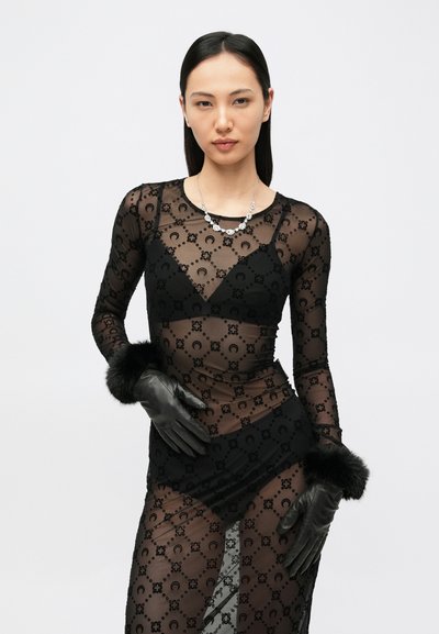 Čierny priehľadný dlhý rukáv s kvetinovým vzorom, kombinovaný s čiernymi koženými rukavicami a umelým kožúškom na manžetách. Strieborné náhrdelníkové detaily.