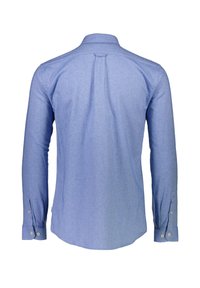 Vaaleansininen pitkähihaisesta paidasta, joka on valmistettu teksturoidusta kankaasta, on takakappale ja napilla varustetut hihansuut. Tässä paidassa on pyöristetyt helmat ja minimaalinen muotoilu.