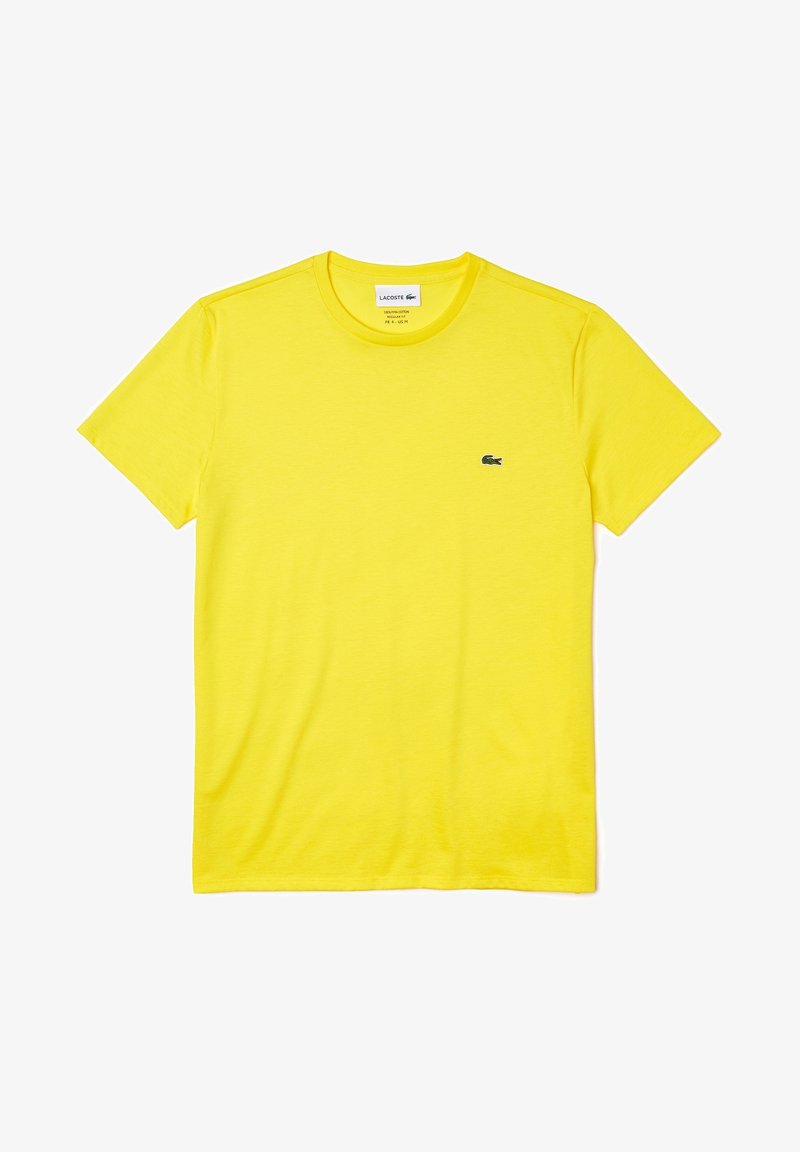 T-shirt en coton jaune vif à manches courtes avec col rond et petit logo crocodile vert Lacoste sur la poitrine gauche.