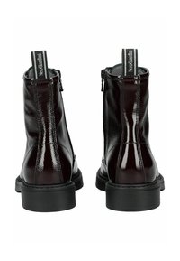 Botines de charol burdeos con textura suave, suela de goma negra y cierre de cremallera en la parte trasera. Detalle de costura sutil.