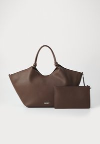 Brązowa skórzana torba tote DKNY z zaokrąglonymi uchwytami, w komplecie z pasującą odpinaną prostokątną saszetką na białym tle.