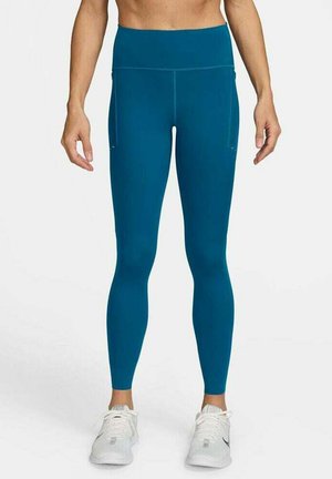 Türkise Fitness-Leggings mit hohem Bund, glatter Textur und Seitentaschen. Entwickelt für aktive Bewegungen, mit einer figurbetonten Passform.