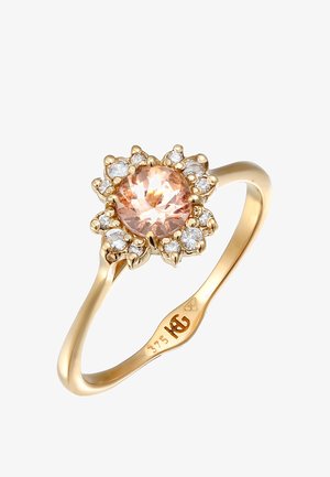 Goldring mit einem zentralen runden Pfirsichstein, umgeben von kleinen klaren Steinen in einem floralen Design. Glatter Band mit gravierten Mustern.