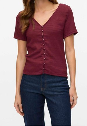 Haut bordeaux à manches courtes avec un décolleté en V et une fermeture à boutons à l'avant de la même couleur ; tissu texturé avec un motif subtil.