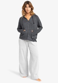 Gray hooded pullover with a v-neckline and front pockets, paired with light gray wide-leg pants featuring a subtle texture.