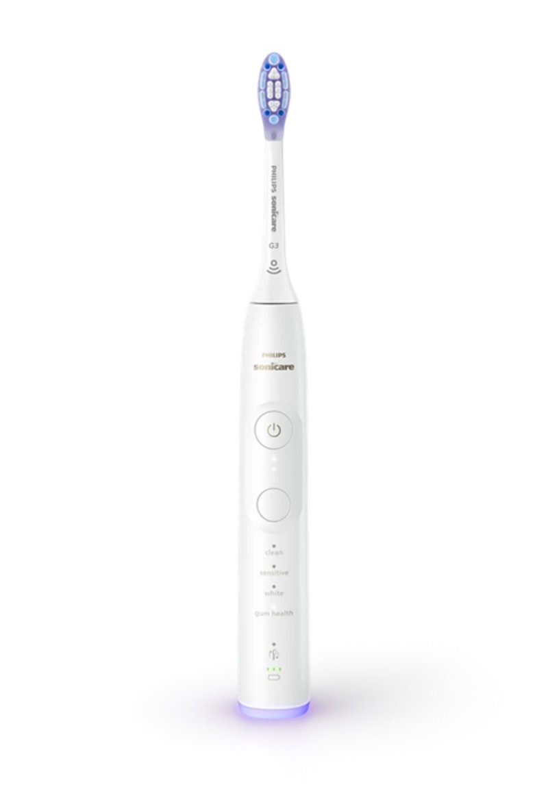 Philips Sonicare elektrische tandenborstel, wit met blauwe accenten, heeft een ronde handgreep, meerdere knoppen voor standen en een verlicht voetstuk.