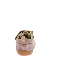 Scarpa per bambini con tomaia in suede beige, accenti rosa chiaro e suola in gomma con una chiusura sicura in velcro al tallone.