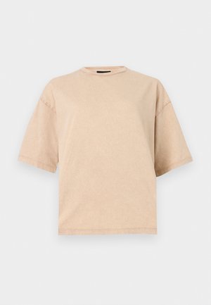 T-shirt beige surdimensionné à manches courtes avec col rond, présenté sur un fond blanc uni.