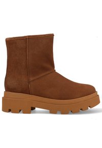 Bruine suède enkelboot met een stevige, gestructureerde zool. Heeft een eenvoudig ontwerp en gestikte accenten. Bovenkant is iets geslouched.