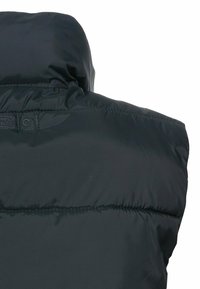 Schwarze Pufferweste mit hohem Kragen, glatter Textur und sichtbaren Nähten. Verfügt über ein Logotag im Nackenbereich.