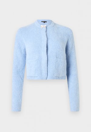 Lichtblauwe, pluizige, korte cardigan met lange mouwen, twee voorzakken en een kleine decoratieve strik bij de halslijn.