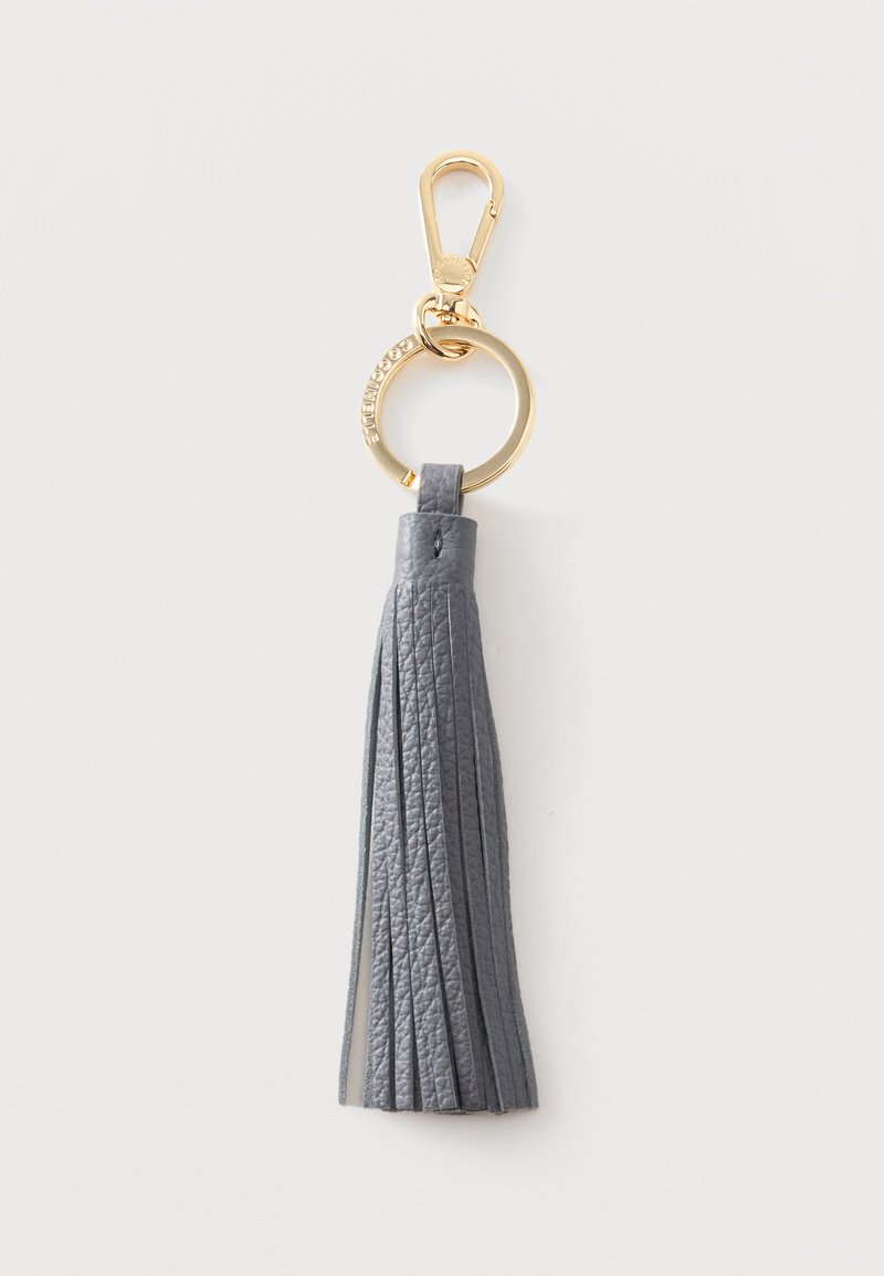 Porte-clés en cuir gris avec pompon, anneau métallique doré et fermoir sur un fond clair uni.