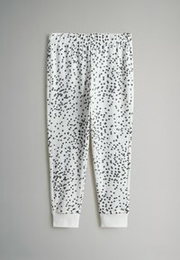 Balti kelni su juodais taškeliais, su elastinga juosmens juosta ir baltais aptempimais ties kulkšnimis. Pagaminti iš minkštos medžiagos.