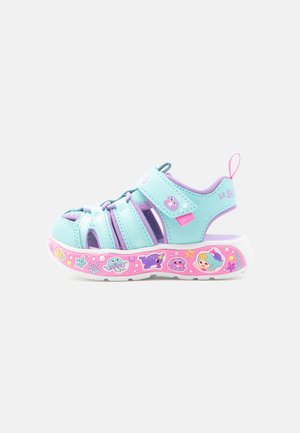 Sandalia para niño pequeña en azul claro y morado con suela rosa, con ilustraciones de criaturas marinas y sirenas, correa ajustable con cierre de velcro.