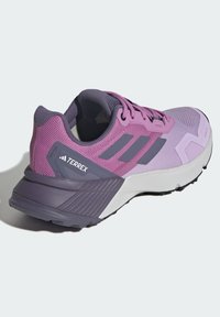 Paarse en lavendel sport schoen met een bovenwerk van mesh, rubberen zool en textuuraccenten; heeft een opvallend drievoudig streep ontwerp en een gebrandmerkte hak.