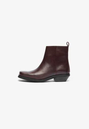 Burgundia nahkadest pahklöödid ümarate varvastega, minimalistlik disain, madal plokknina ja tõmmata tab tagaküljel. Sile tekstuur ja viimistlus.