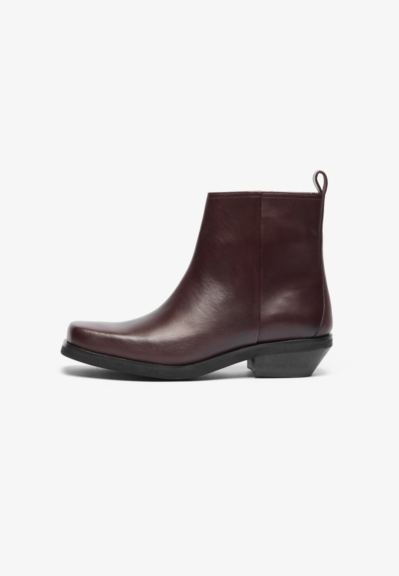 Botas de tobillo de cuero burdeos con punta redonda, diseño minimalista, un tacón bajo en bloque y una lengüeta en la parte posterior. Textura y acabado suaves.