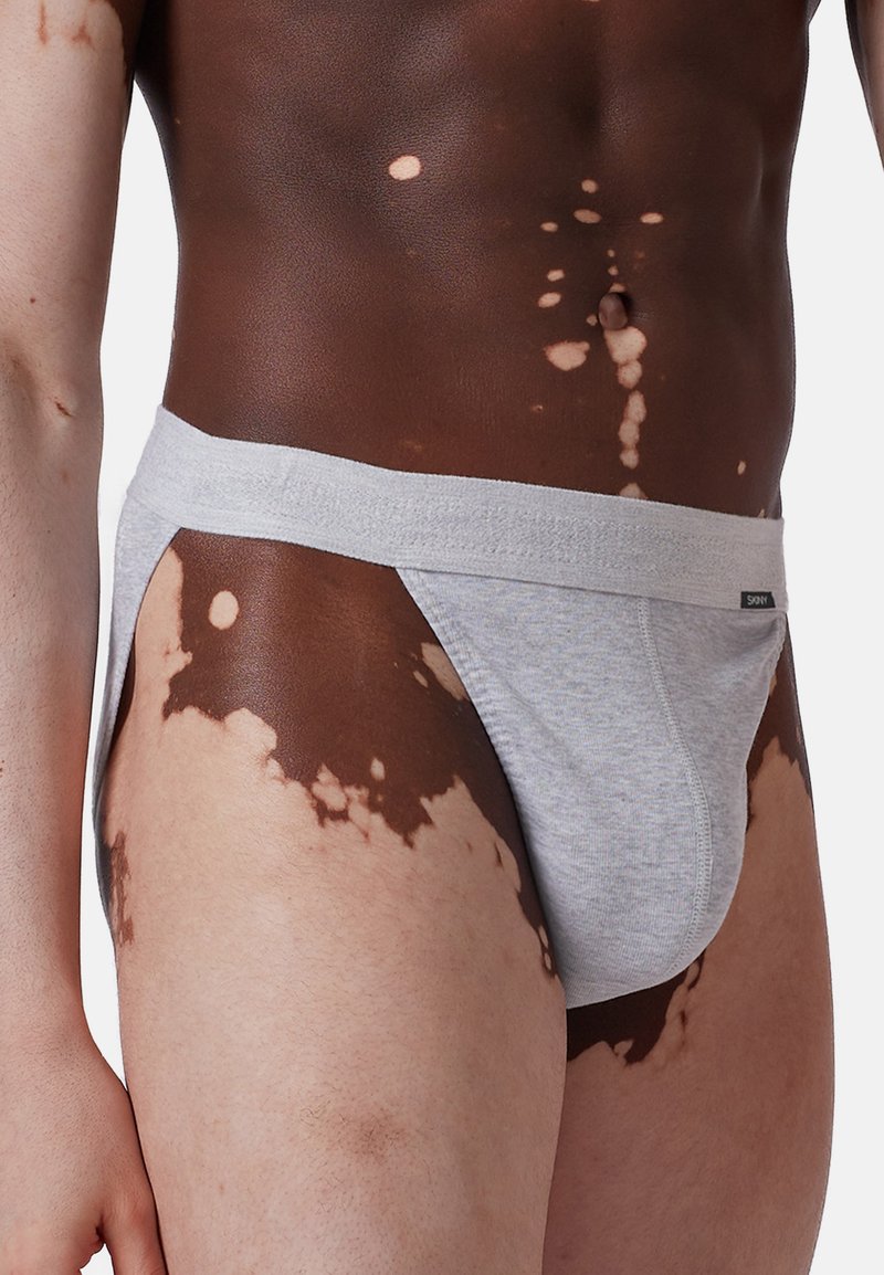 Jasnoszare, bawełniane majtki z szerokim paskiem w talii. Posiadają klasyczny krój z niskim stanem i bocznymi wycięciami, które zapewniają minimalne zakrycie.