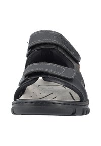 Sandale noire avec deux sangles à velcro réglables. Semelle intérieure texturée et semelle confortable. Semelle extérieure en caoutchouc avec motif pour une meilleure adhérence.