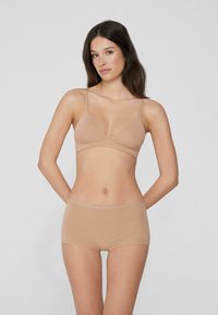 Bralette marron clair avec des bretelles fines et un design en V, assortie à un shorty marron clair. Tissu doux et extensible, texture lisse.