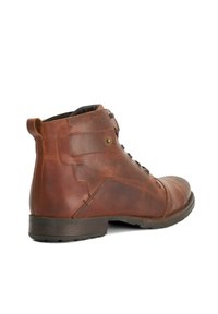 Brown leather ankle boots with a rounded toe, lace-up front, and a small heel. Features a tab on the back and brass hardware detail.