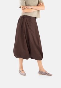 Brązowe, balonowe kuloty wykonane z lekkiego materiału, z wysokim stanem, bocznymi kieszeniami i luźnym krojem.