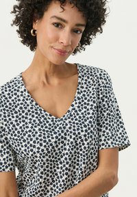 T-shirt a maniche corte con scollatura a V di colore bianco, con stampa floreale navy, caratterizzato da una vestibilità comoda e un tessuto morbido.