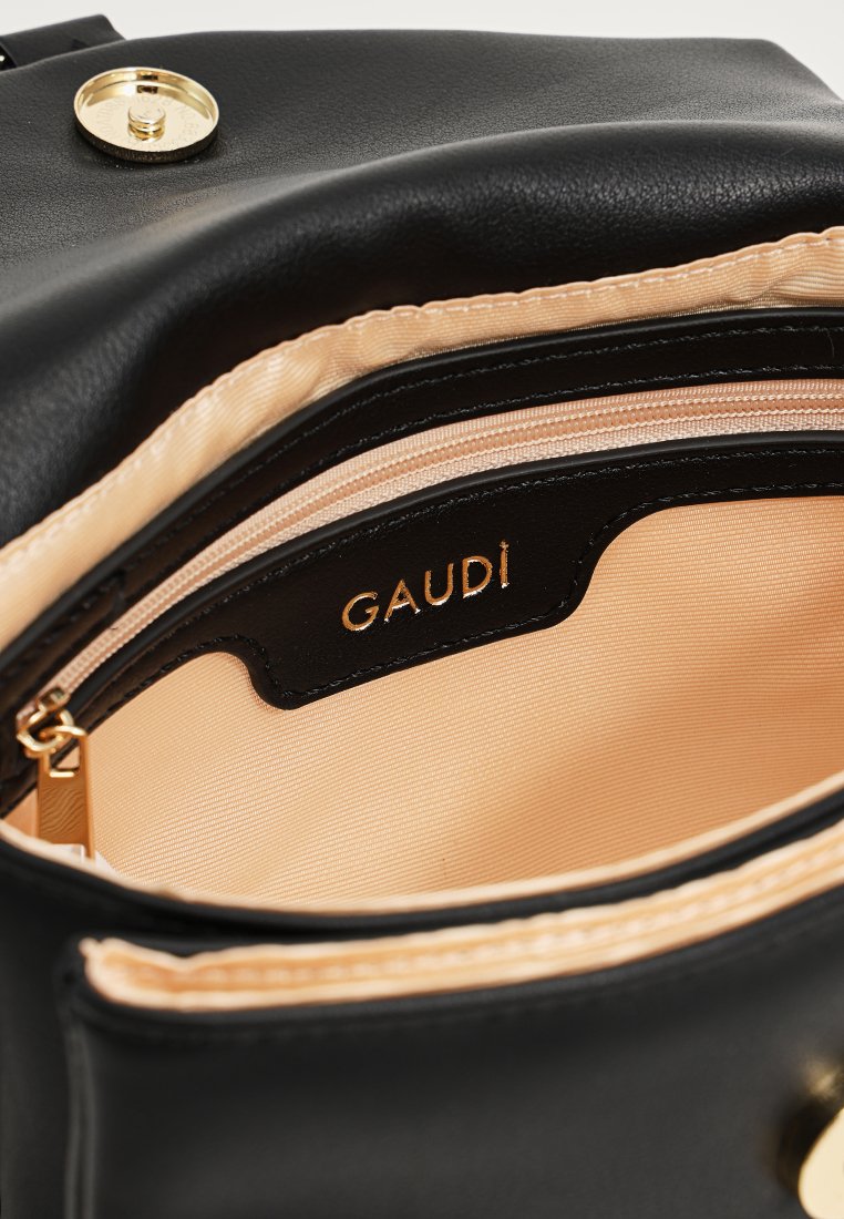 Zwarte leren handtas met een gladde textuur, voorzien van een beige satijnen voering en een gouden logo daarin. Inclusief een ritszak.